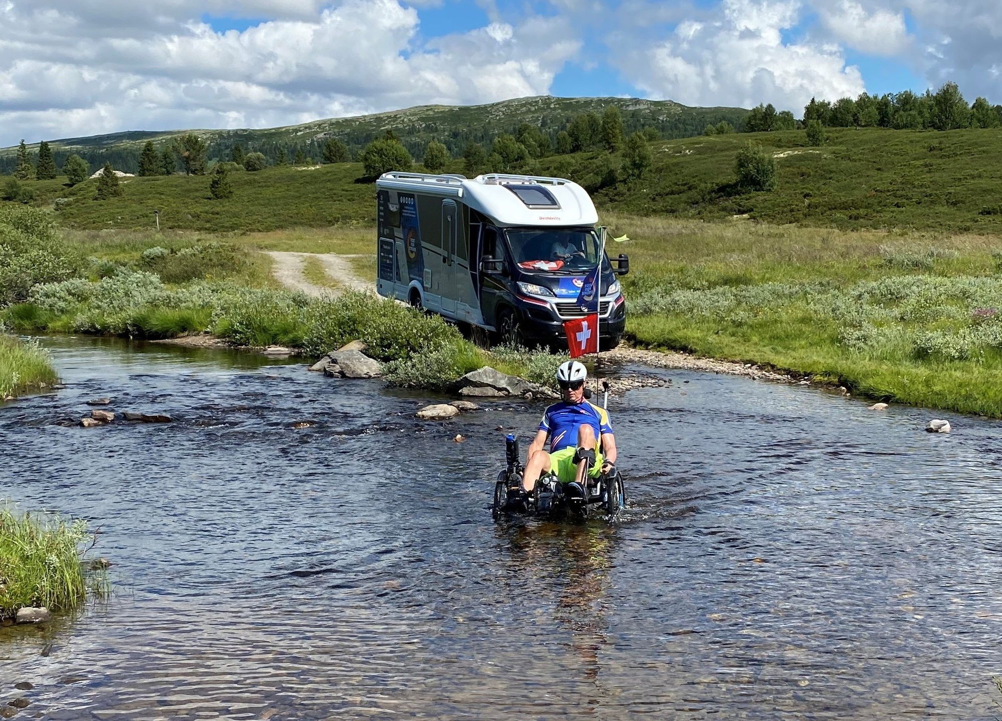 Christian Salamin, suivi par son camping-car, traverse une étendue d'eau.