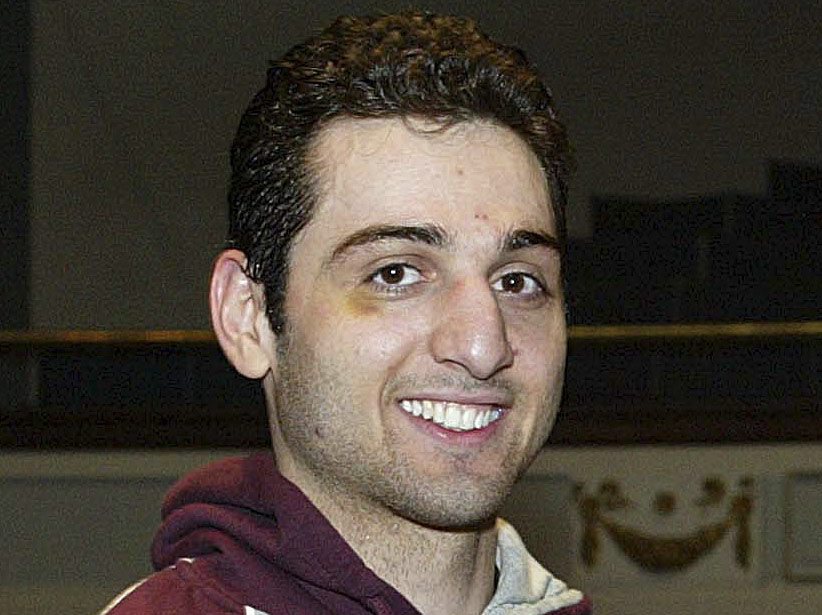 FILE - In this Feb. 17, 2010, photo, Tamerlan Tsarnaev, left, smiles after accepting the trophy for winning the 2010 New England Golden Gloves Championship in Lowell, Mass. Tsarnaev, the older of the brothers suspected in the Boston Marathon bombing, died from gunshot wounds and blunt trauma to his head and torso, his death certificate says. (AP Photo/The Lowell Sun, Julia Malakie, File) MANDATORY CREDIT