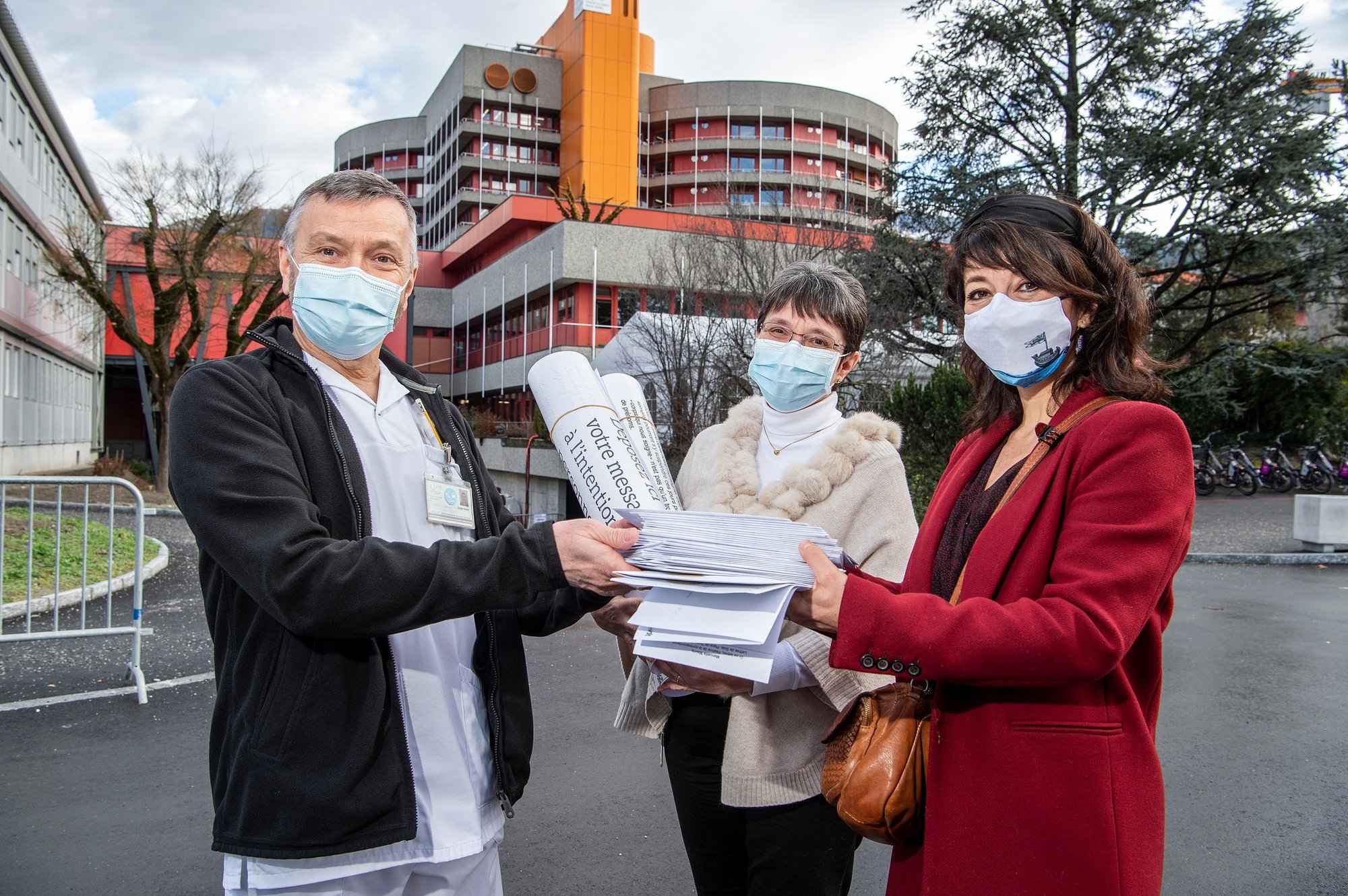 Manuella Maury (à droite) et le festival Lettres de Soie remettent 42 lettres destinées au personnel soignant de l'Hôpital de Sion aux Dr. Didier Blanc et Hélène Hertzog.