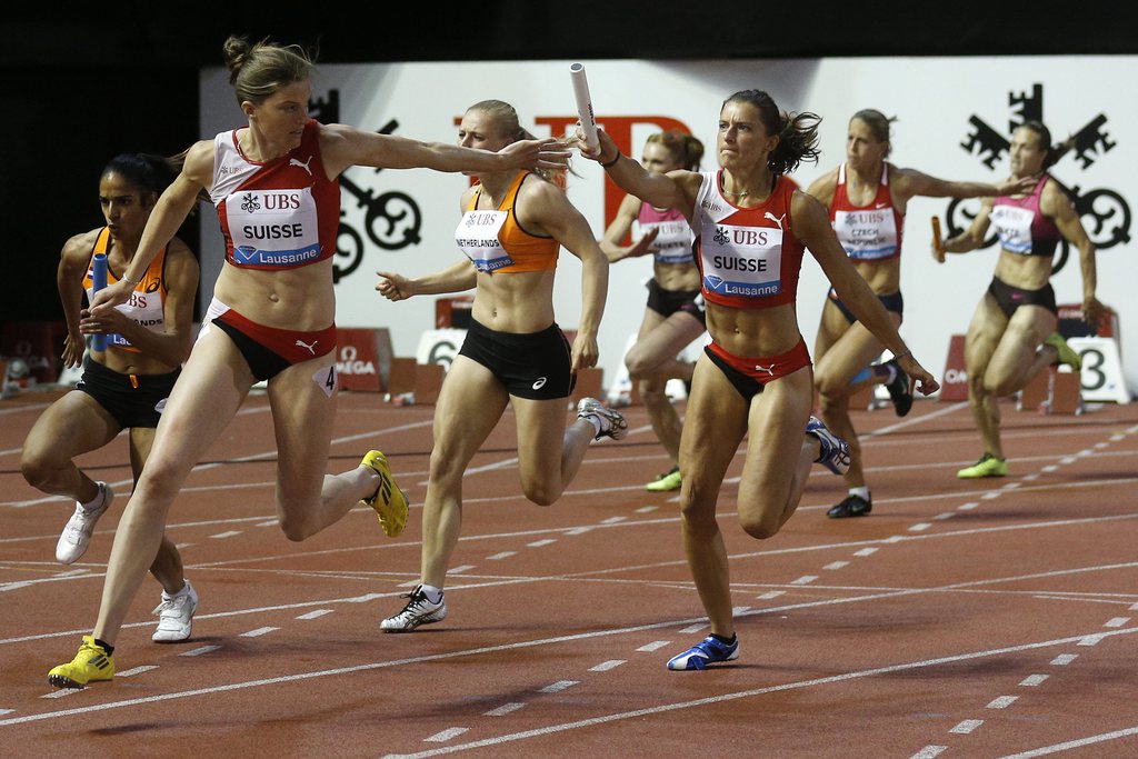 Ellen Sprunger gives the batton to her sister Lea Sprunger, during the 4x100m race, at the Athletissima IAAF Diamond League athletics meeting in the Stade Olympique de la Pontaise in Lausanne, Switzerland, on Thursday, July 4, 2013. (KEYSTONE/Peter Klaunzer)....