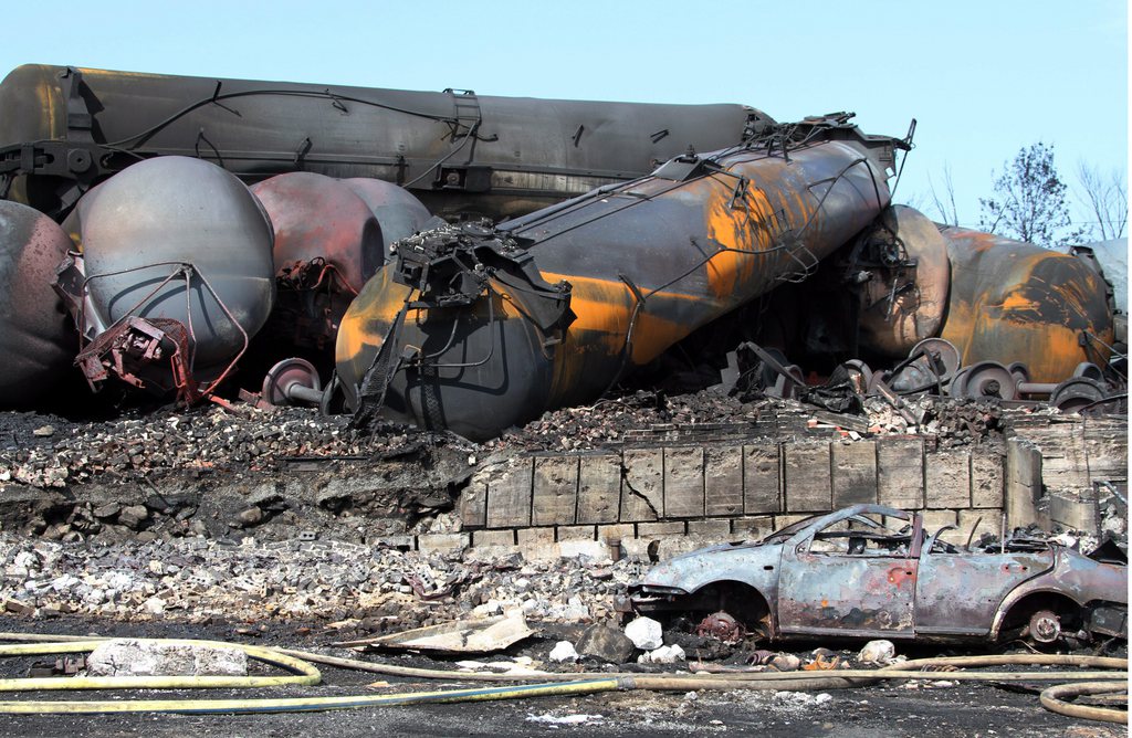 This photo provided by Surete du Quebec, shows wrecked oil tankers and debris  from a runaway train on Monday, July 8, 2013 in Lac-Megantic, Quebec, Canada.  A runaway train derailed igniting tanker cars carrying crude oil early Saturday, July 6.  At least thirteen people were confirmed dead and nearly 40 others were still missing in a catastrophe that raised questions about the safety of transporting oil by rail instead of pipeline.  (AP Photo/Surete du Quebec, The Canadian Press)