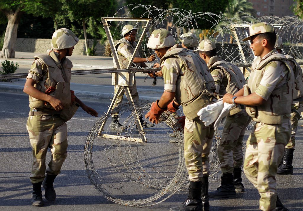 epa03829971 Egyptian soldiers place barbed wire to block the way leading to the constitutional court ahead of an anounced protest called for by the Muslim brotherhood in Cairo, Egypt, 18 August 2013.  The Muslim brotherhood had on 17 August called for new protests against the ousting of president Morsi. On 18 August afternoon, local media reported their cancelation for the one planned in Roxy located in the Heliopolis area of Cairo,  but it was not clear yet whether all the other marches have been canceled.Army chief and Defence Minister Abdel-Fattah al-Sissi has warned Morsi's supporters to refrain from 'destroying the country and or the torching the nation and terrorizing the citizens.  EPA/AL YOUM ELSABAA NEWSPAPER
