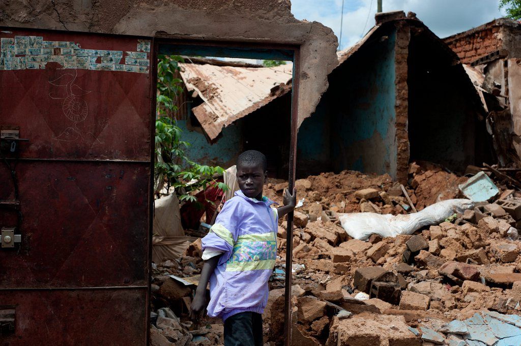 A young boy stands amidst the remains of his house, destroyed by flooding, in the Banconi neighborhood of Bamako, Mali, Thursday, Aug. 29, 2013. Scores of panicked relatives are crowding morgues in Mali's capital Thursday. A government statement read on state television confirmed 24 deaths after Wednesday's storm, though private newspapers were reporting more than 50 killed. (AP Photo/Emilie Regnier)