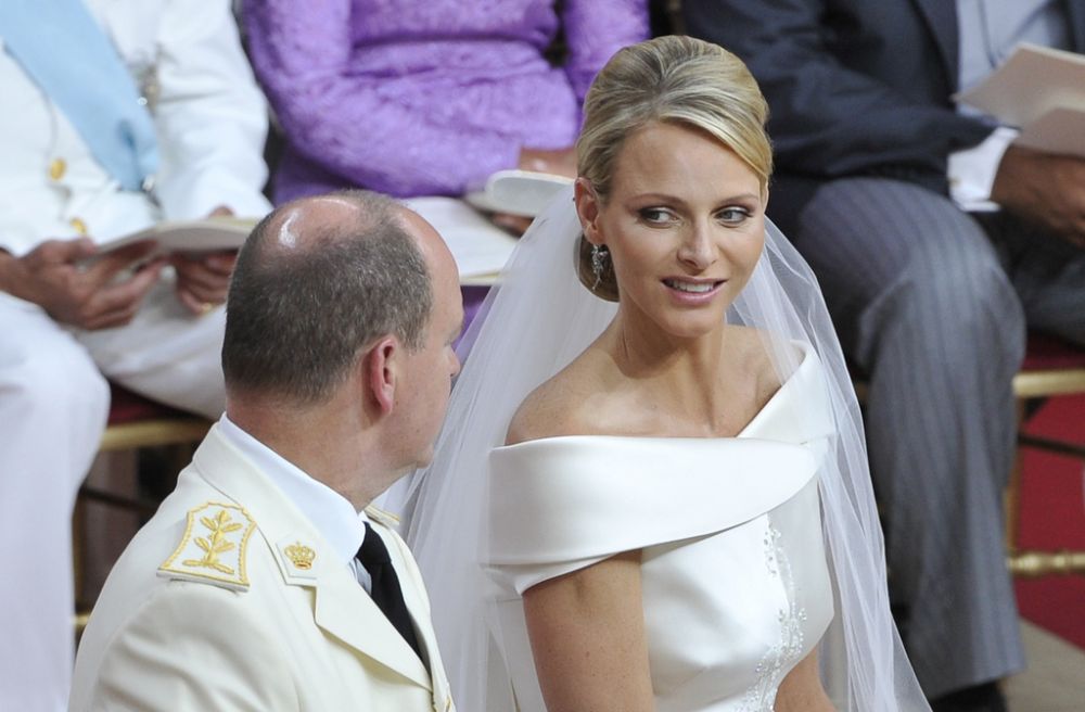 Princess Charlene (R) smiles to her husband, Prince Albert II of Monaco (L) during their wedding mass in the Main Courtyard of the Prince's Palace in Monaco, July 2, 2011. Some 850 guests attend the religious ceremony in the Main Courtyard. The ceremony is broadcasted on giant screens in the Palace Square for about 3,500 Monegasques. Her dress was created by Italian designer by Giorgio Armani.  (AP Photo/Bruno Bebert, Pool)