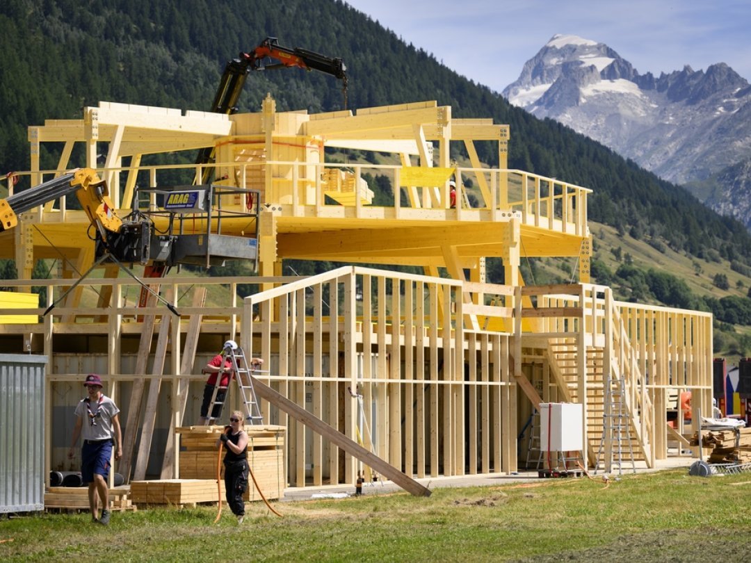 Des ouvriers montent un bâtiment en bois en prévision du camp fédéral.