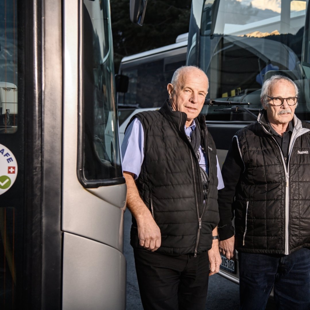 Jean-Mary et Régis Ballestraz, co-directeurs des Cars Ballestraz, posent devant les deux véhicules qui constitueront encore la flotte du transporteur après la fin de leur concession de transport public.