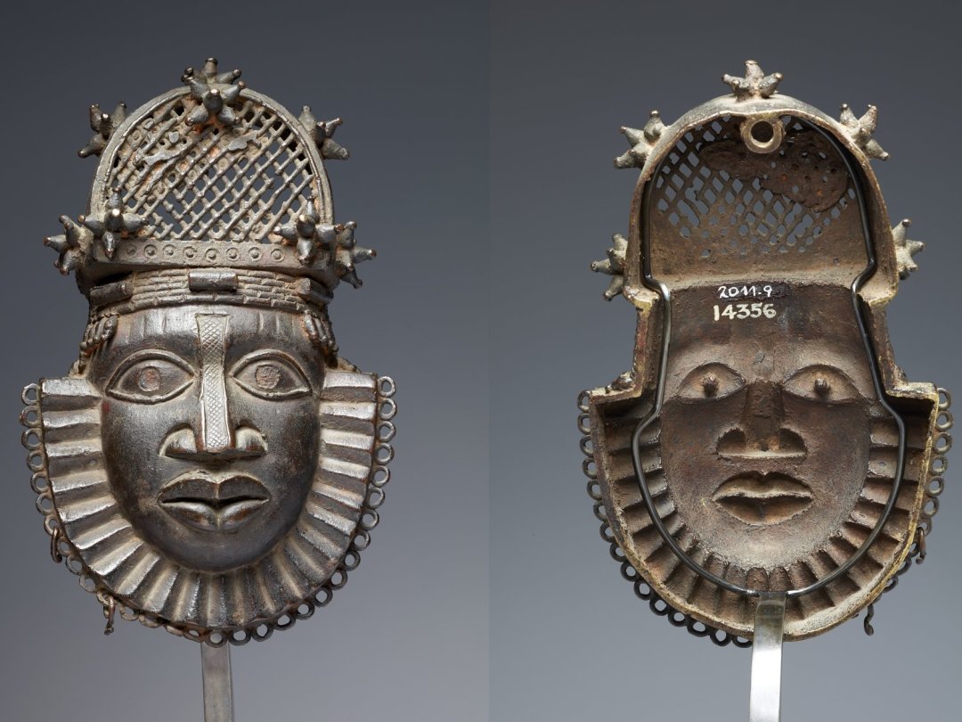Boucle de ceinture en forme de masque provenant de l'atelier de la cour du Royaume du Bénin, datée entre le 17e et 18e siècle. A son dos (à droite), le numéro blanc indique qu'elle provient de la collection du marchand d'art anglais William D. Webster.