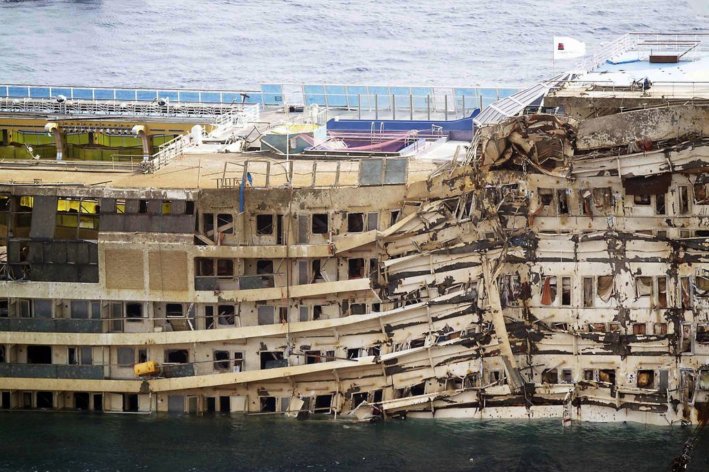 The Costa Concordia is seen after it was lifted upright, on the Tuscan Island of Giglio, Italy, Tuesday, Sept. 17, 2013. The crippled cruise ship was pulled completely upright early Tuesday after a complicated, 19-hour operation to wrench it from its side where it capsized last year off Tuscany, with officials declaring it a "perfect" end to a daring and unprecedented engineering feat. (AP Photo/Alessandro La Rocca, Lapresse) ITALY OUT
