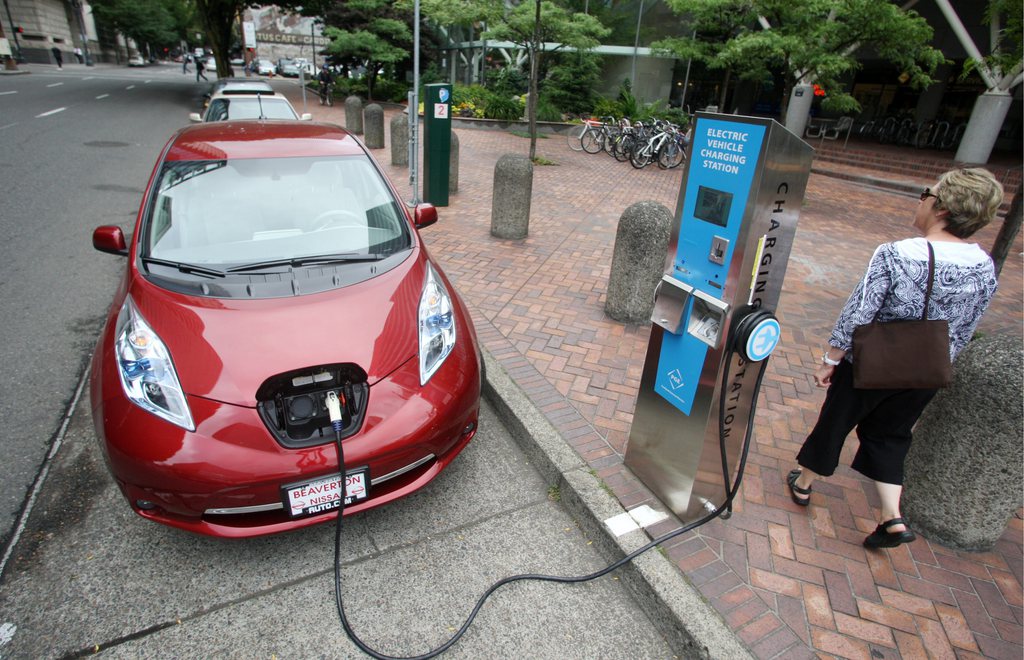 FILE - In this Aug. 18, 2011 file photo, A Nissan Leaf charges at a electric vehicle charging station in Portland, Ore. Automakers have sweetened deals in recent months for plug-in electric cars in a bid to boost sales and move the vehicles off dealer lots as the end of the year nears. Earlier in 2013, Nissan dropped the price of its electric Leaf, helping boost its sales. It?s now offering a three-year lease at $199 a month. (AP Photo/Rick Bowmer, File)