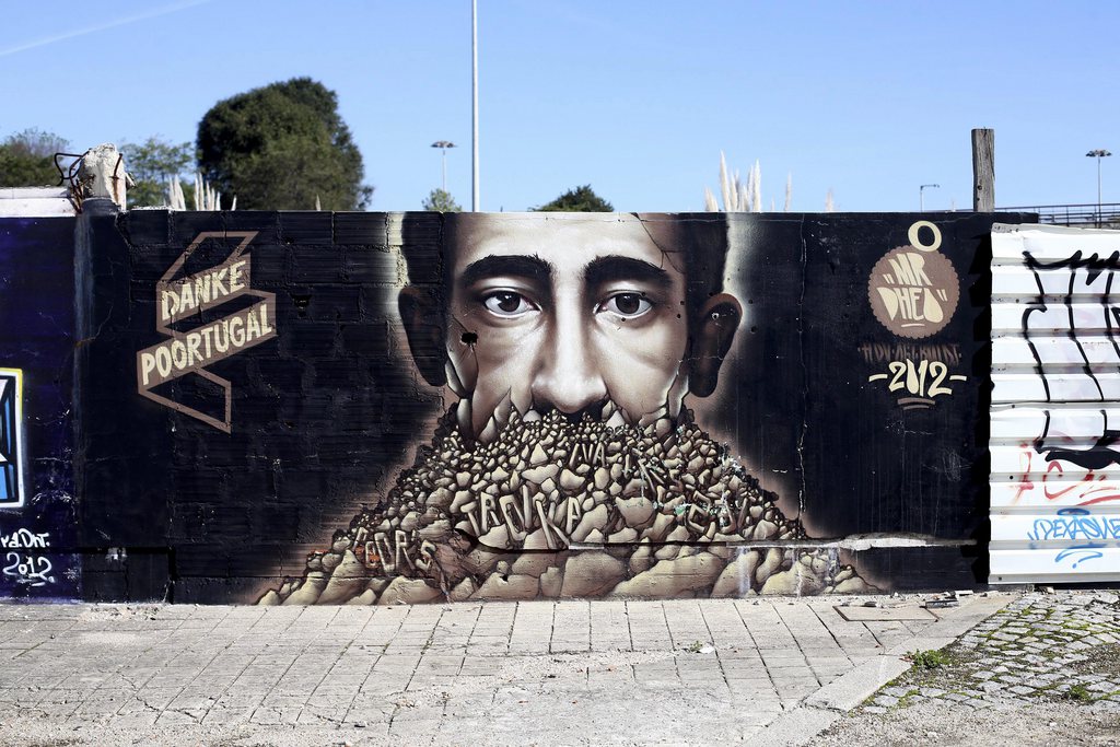 Un graffiti par l'artiste portugais M. Dheo représente la crise économique portugais en utilisant une image d'un homme couvert de pierres, et parmi eux plusieurs mots (TVA, pauvre, troïka) et un souci »Danke Poortugal '(Merci Poortugal)
