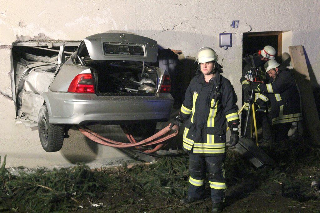 epa03990048 Rescuers work at the scene where a car had crashed into a house in Ochsenhausen-Reinstetten, Germany, late 13 December 2013. According to the police, the driver apparently lost control of the car, went off the road and crashed through the window of a living room after a 15 meter jump. The driver died in the accident, while the two residents were severely injured.  EPA/THOMAS POEPPEL