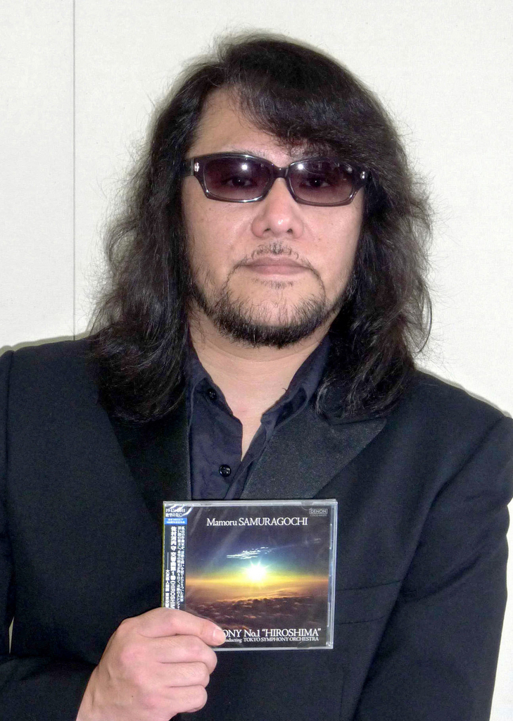 In this 2011 photo, Mamoru Samuragochi poses with his CD "Symphony No.1 Hiroshima" in Japan. Samuragochi has been lauded as Japan's Beethoven for composing music despite a severe hearing impairment. But he admitted Wednesday, Feb. 5, 2014 that he did not write the symphony and other works credited to him. His ghostwriter Takashi Niigaki said Thursday, Feb. 6, that he worked with Samuragochi for 18 years but got fed up and refused in 2013 to continue the collaboration. Niigaki said he hopes to continue composing and performing despite the uproar. (AP Photo/Kyodo News) JAPAN OUT, MANDATORY CREDIT