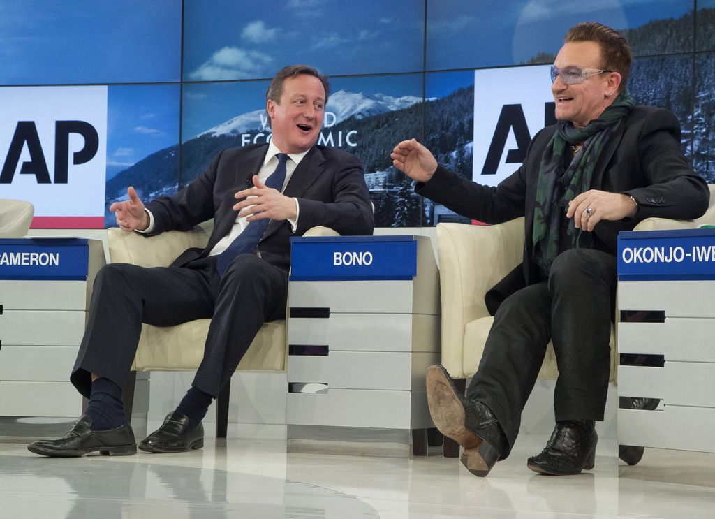 British Prime Minister David Cameron, left, and  rock star Bono speak during the panel discussion  "The Post-2015 Goals: Inspiring a New Generation to Act", the fifth annual Associated Press debate, at the World Economic Forum in Davos, Switzerland, Friday, Jan. 24, 2014.  (AP Photo/Michel Euler)