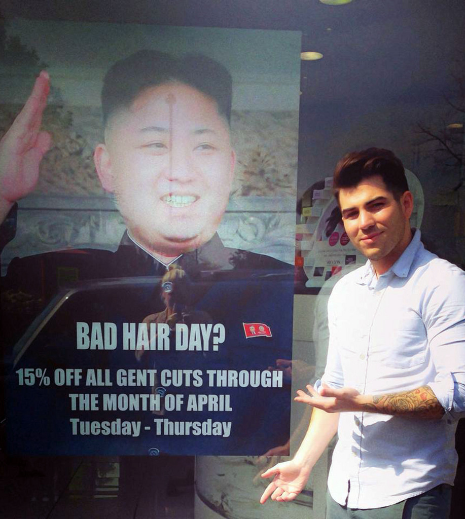 This undated photo provided by M&M Hair Academy in South Ealing, west London, shows barber Karim Nabbach standing next to a poster poking fun at North Korean leader Kim Jong-un unusual hairstyle. North Korean diplomats have asked the British government take action against a London hair salon?s poster poking fun at distinctively coiffured leader Kim Jong Un. The Foreign Office said Wednesday it had received a letter from the country?s embassy objecting to the poster, and was considering its response. The Evening Standard newspaper reported that the letter urged Britain to take ?necessary action to stop the provocation.? Staff at M&M Hair Academy say they were visited by diplomats from the nearby embassy after putting up a poster featuring a picture of Kim - who sports a distinctive undercut - and the slogan "Bad Hair Day?" Police say they spoke to both parties and determined no crime had been committed. The embassy didn?t immediately respond to a request for comment. (AP Photo/M&M Hair Academy)