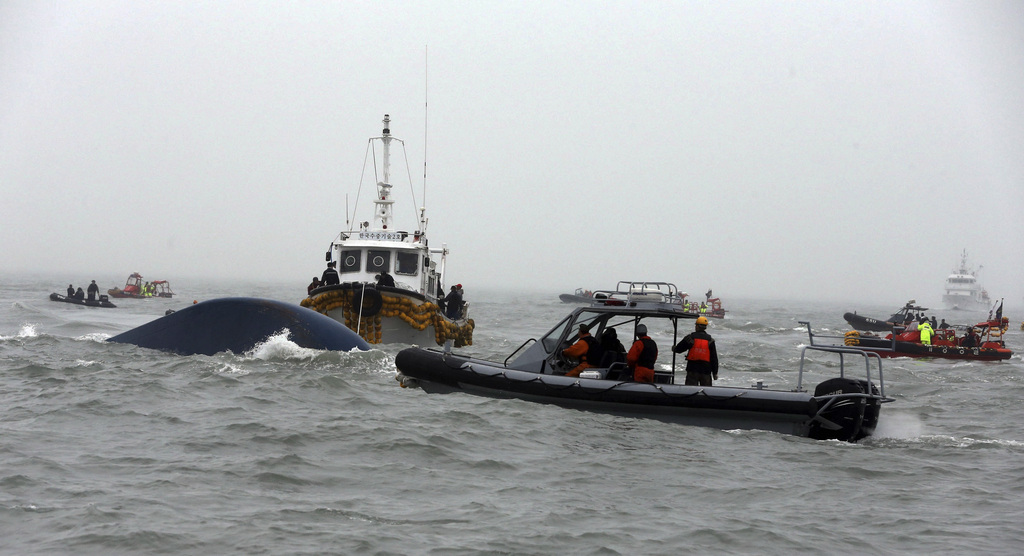 South Korean Coast Guard officers try to search missing passengers aboard the Sewol ferry in the water off the southern coast near Jindo, South Korea, Friday, April 18, 2014. The captain of the doomed ferry delayed evacuation for half an hour after a South Korean transportation official ordered preparations to abandon ship, raising more questions about whether quick action could have saved scores of passengers still missing Friday and feared dead, according to a transcript of the ship-to-shore exchange and interviews with a crewmember. (AP Photo/Yonhap)  KOREA OUT