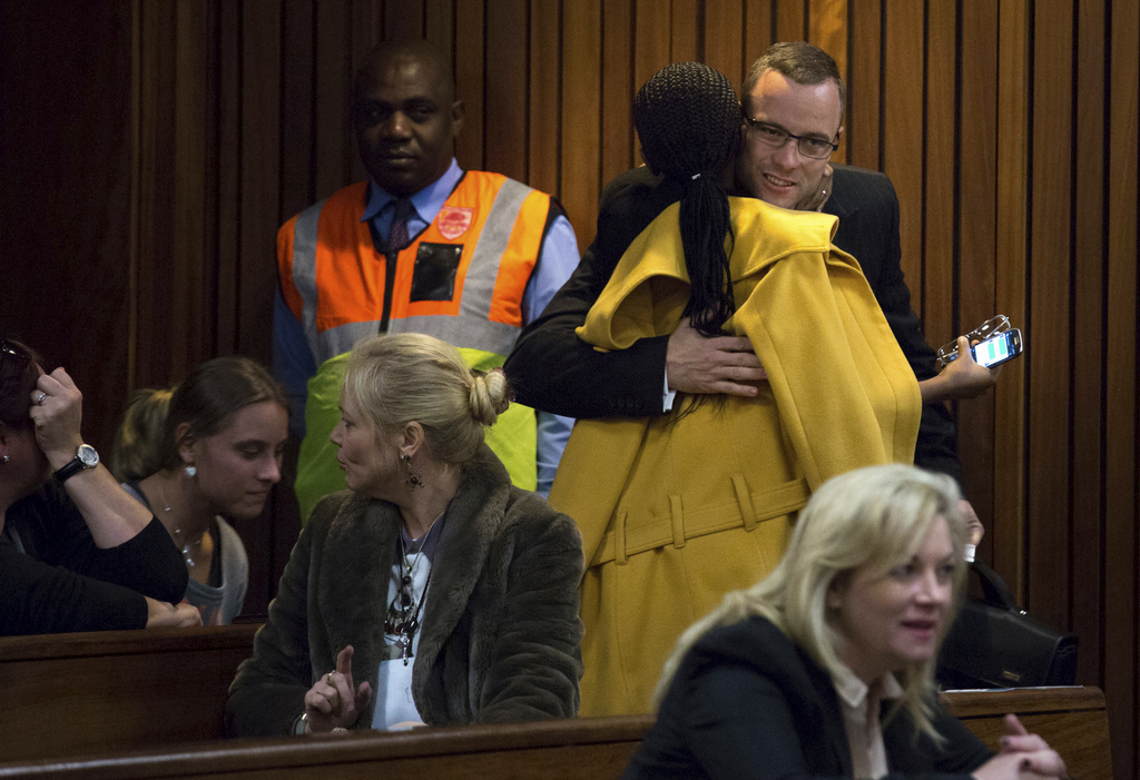 Oscar Pistorius, top right, is greeted by a supporter on his arrival in court for his ongoing murder trial in Pretoria, South Africa, Tuesday, May 13, 2014. Pistorius is charged with the shooting death of his girlfriend Reeva Steenkamp on Valentine's Day in 2013. (AP Photo/Daniel Born, Pool)