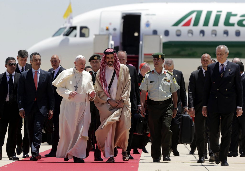 epa04221868 Pope Francis (C-L) walks with Jordanian Prince Ghazi (C-R), Chief Advisor to the King of Jordan for Religious and Cultural Affairs, upon his arrival at Amman airport, Amman, Jordan, 24 May 2014. Pope Francis arrived on his first official visit to the Holy Land from 24 to 26 May.  EPA/AMEL PAIN