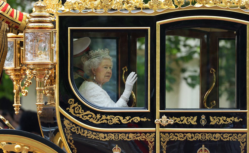 epa04238970 Britain's Queen Elizabeth II makes her way by royal carriage along The Mall for her State Opening of Parliament Speech in London, Britain, 04 June 2014.  EPA/ANDY RAIN