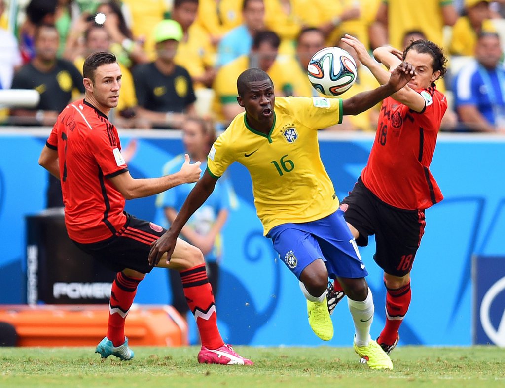 Ramires aux prises avec Layun (à gauche) et Guardado (à droite). Le Brésil et le Mexique se battent pour la première place du groupe A. 
