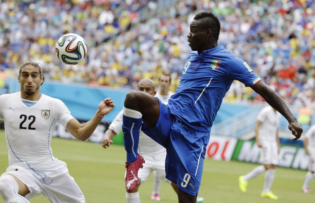 L'Italien Mario Balotelli et l'Uruguayen Martin Caceres lors du match de Coupe du monde mardi.