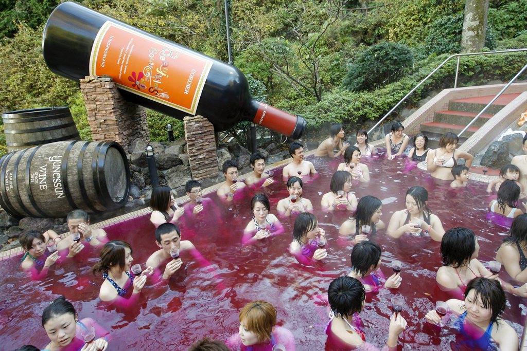 epa01555788 Guests bathe in a pool of the red wine with their glasses to celebrate this year's release of the Beaujolais Nouveau wine during the opening of Beaujolais Nouveau wine spa at the Hakone Yunessun spa resort in Hakone town, one of Japan's most popular hot spring resorts located some 100kms southwest of Tokyo, Japan, 20 November 2008. Guests enjoyed bathing and swimming in a pool of the red wine at an open-air-wine-spa after the embargo on the wine was removed at midnight on 20 November. Japanese retailers and other businesses are trying to cope with declining popularity and demand for the Beaujolais Nouveau wine in the country by cutting imports, reducing the prices etc. The consumer fad for the Beaujolais Nouveau in Japan is phasing out as many Japanese realize that many other wine varieties taste good and are less expensive.  EPA/DAI KUROKAWA