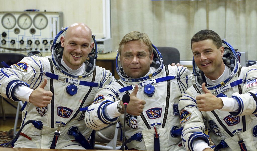 European Space Agency's astronaut Alexander Gerst, left, Russian cosmonaut Maxim Suraev, center, and NASA astronaut Reid Wiseman, crew members of the mission to the International Space Station, ISS, gesture prior the launch of Soyuz-FG rocket at the Russian leased Baikonur cosmodrome, Kazakhstan, Wednesday, May 28, 2014.  (AP Photo/Sergei Ilnitsky, Pool)