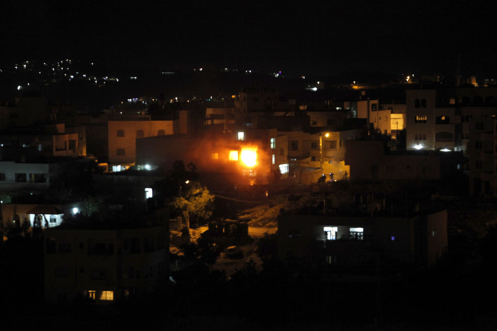 Dans la ville d'Hébron en Cisjordanie, des flammes s'échappent de la maison de l'un des deux Palestiniens identifiés par Israël comme suspects dans le meurtre de trois adolescents israéliens.