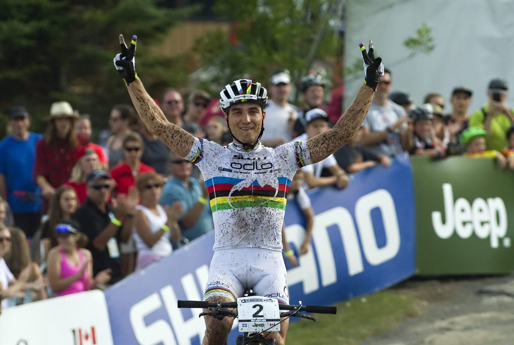Nino Schurter, of Switzerland, celebrates after finishing the men's cross country bike event Sunday, Aug. 3, 2014 at the UCI mountain bike world cup at Mont-Sainte-Anne in Beaupre, Quebec. Schurter finished first. (AP Photo/The Canadian Press, Clement Allard)