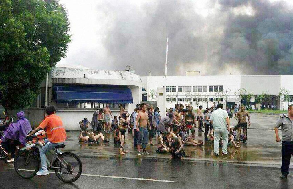 epa04338458 A picture taken with a mobile phone shows injured people waiting for medical help after an explosion at an automotive parts factory that supplies General Motors in Kunshan, Jiangsu province, China, 02 August 2014. At least 65 people were killed in the morning blast and over 100 injured. An initial investigation found the explosion could have been caused by flames igniting dust in the workshop, media reported.  EPA/FEATURECHINA CHINA OUT -- BEST QUALITY AVAILABLE