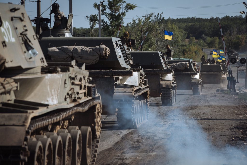 epa04382946 Ukrainian tanks drive on a road on the outskirts in the eastern Ukrainian city Slaviansk, Ukraine, 03 September 2014. Russian President Vladimir Putin and Ukrainian President Petro Poroshenko agreed on joint steps to solve the conflict in eastern Ukraine, the offices of both leaders said on 03 September after a telephone conversation between the two.  EPA/ROMAN PILIPEY
