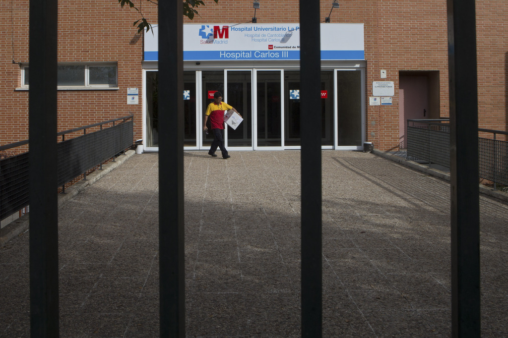 A workers makes a delivery at the entrance of the Carlos III  hospital in Madrid, Spain, Tuesday, Oct. 7, 2014 where a Spanish nurse who is believed to have contracted the ebola virus from a 69-year-old Spanish priest is being treated after testing positive for the virus. Raising fresh concern around the world, the nurse in Spain became the first person known to catch Ebola outside the outbreak zone in West Africa. In Spain, the stricken nurse had been part of a team that treated two missionaries flown home to Spain after becoming infected with Ebola in West Africa. The nurse's only symptom was a fever, but the infection was confirmed by two tests, Spanish health officials said. She was being treated in isolation, while authorities drew up a list of people she had had contact with. (AP Photo/Paul White)