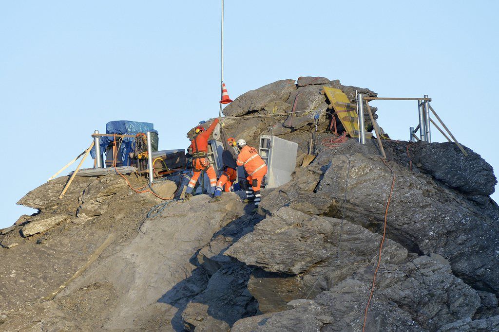 Des ouvriers participent a la construction du premier pont suspendu au monde, qui relie deux sommets entre eux, ce mercredi 3 septembre 2014, au Col du Pillon aux Diablerets. (KEYSTONE/Christian Brun)