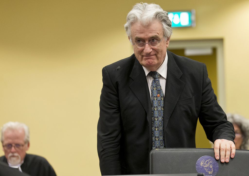 Former Bosnian Serb leader Radovan Karadzic, right, enters the courtroom of the U.N. Yugoslav war crimes tribunal (ICTY) in The Hague, Netherlands, Thursday, July 11, 2013. Judges at the ICTY are ruling on a prosecution appeal against Karadzic's acquittal on genocide charge, one of the key allegations against him over atrocities during Bosnia's bloody war. (AP Photo/Michael Kooren, Pool)