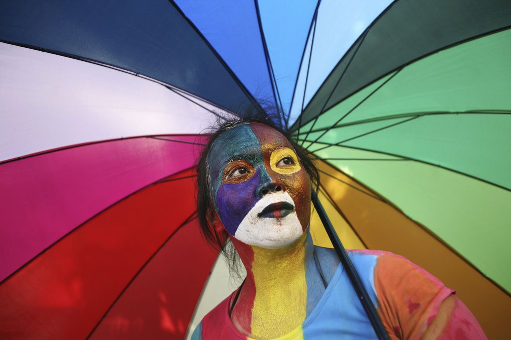 FILE - An activist with multicolored paint on her face and matching umbrella particiaptes a protest demanding equality for LGBTIQ (Lesbian, gay, bisexual, transgender and questioning) people in Medan, North Sumatra, Indonesia on Friday, May 31, 2012. In heavily Muslim Indonesia, gay sex is not criminalized, and many young, urban Indonesians are relatively tolerant of homosexuality, but most citizens consider it unacceptable. "Gay people are still living in fear," said King Oey, chairman of the country's main gay-rights group. (AP Photo/Binsar Bakkara)