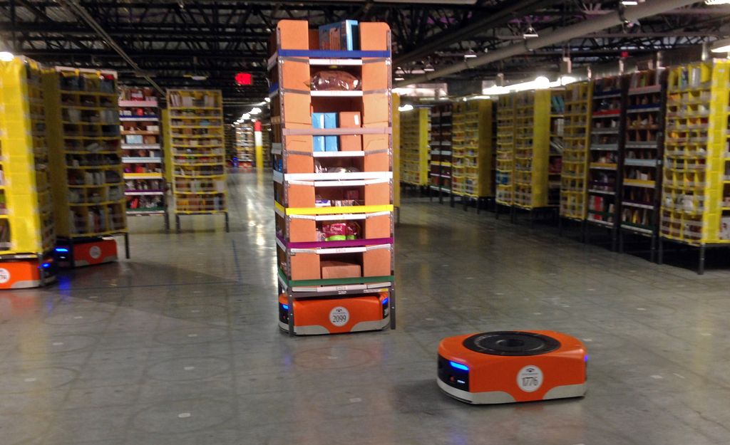 A Kiva robot drive unit is seen, foreground, before it moves under a stack of merchandise pods, seen on a tour of one of Amazon's newest distribution centers in Tracy, Calif., Sunday, Nov. 30, 2014. This Amazon Fulfillment Center opened in 2013 and was refitted to use new robot technology in the summer of 2014. All year Amazon has been investing in ways to make shipping faster and easier to prepare for this holiday season. At this Northern California warehouse the company is employing robotics and other new technology to help workers process the annual onslaught of shopping orders. (AP Photo/Brandon Bailey)