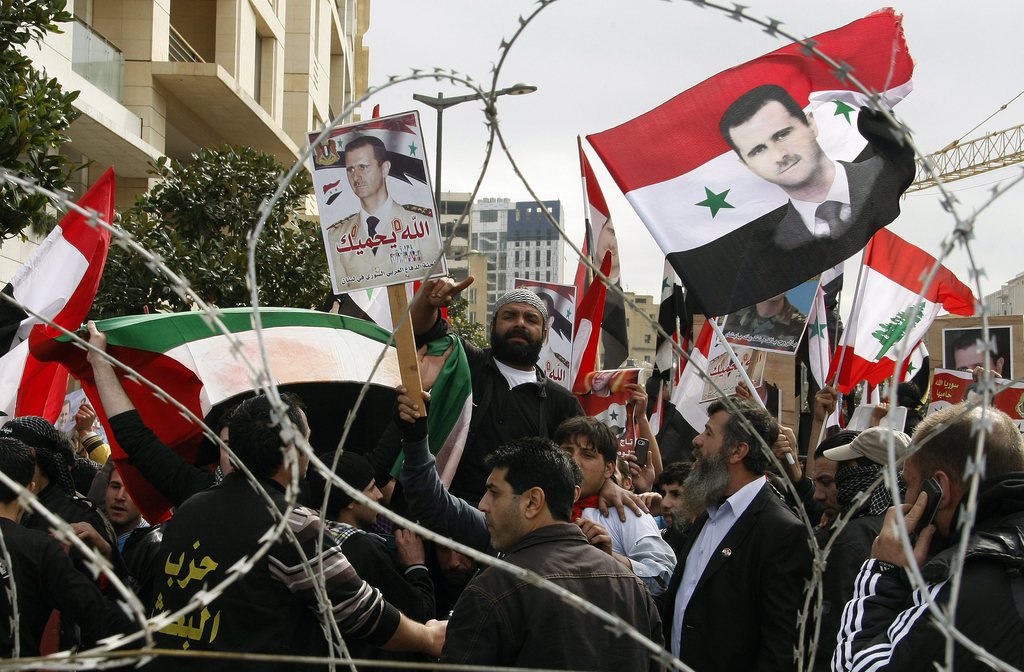 epa03131834 Syrian and Lebanese supporters to Al-Baath Syrian party wave Syrian and Lebanese flags, holding posters depicting the Syrian President Bashar al-Assad, during a rally in downtown Beirut, Lebanon, 04 March 2012. Hundreds supporters of President Bashar al-Assad protested in downtown Beirut on 04 March, chanting against Saudi king Abdullah and Qatari prince Hamad Bin Jassem, while hundreds of Salafist Muslims Anti Syrian regime protesters call for 'Jihad'.  EPA/NABIL MOUNZER