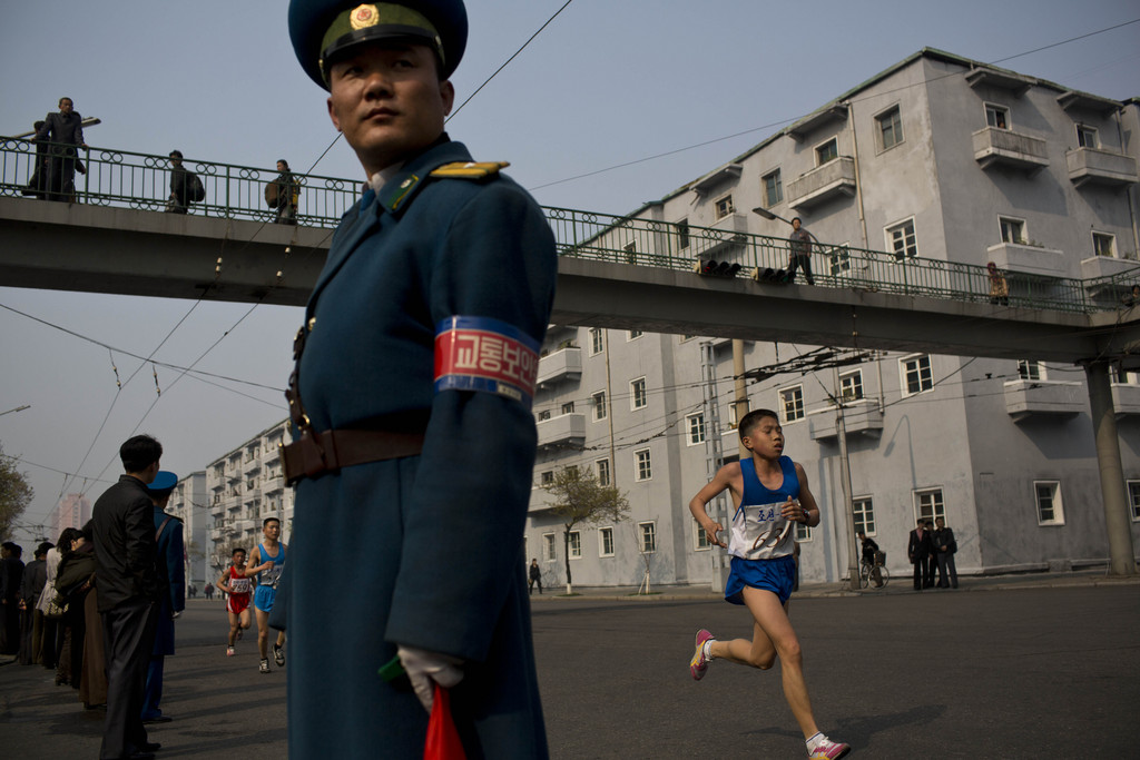 Runners pass under a pedestrian bridge in central Pyongyang during the running of the Mangyongdae Prize International Marathon in Pyongyang, North Korea on Sunday, April 13, 2014. The annual race, which includes a full marathon, a half marathon, and a 10-kilometer run, was open to foreign tourists for the first time this year. (AP Photo/David Guttenfelder)