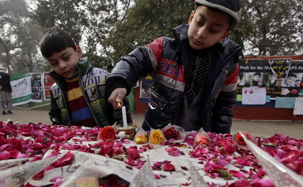epa04539259 Children light candles for the victims of school attack outside the Army Public School in Peshawar, Pakistan, 24 December 2014. A week after the attack on the Peshawar school which left 136 school children dead, Pakistani authorities have said political and military leaders are meeting to formulate a new strategy to counter Taliban insurgents and their ideology.  EPA/ARSHAD ARBAB