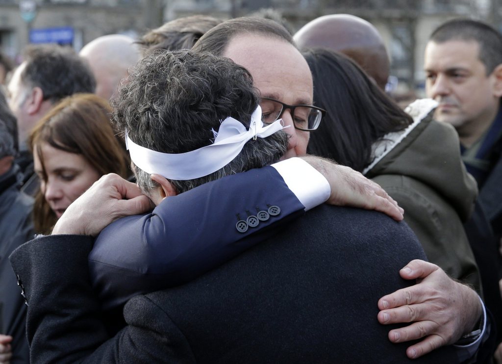 François Hollande enlaçant le collaborateur de Charlie Hebdo Patrick Pelloux, aujourd'hui sur le départ.