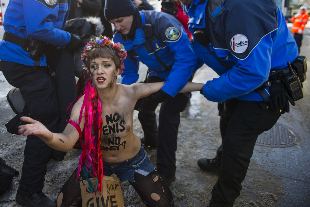 Swiss police officers drag away an activist of the Women's Movement FEMEN in the security zone at the 45th Annual Meeting of the World Economic Forum, WEF, in Davos, Switzerland, Thursday, January 22, 2015. The overarching theme of the Meeting, which takes place from 21 to 24 January, is "The New Global Context". (KEYSTONE/Jean-Christophe Bott)