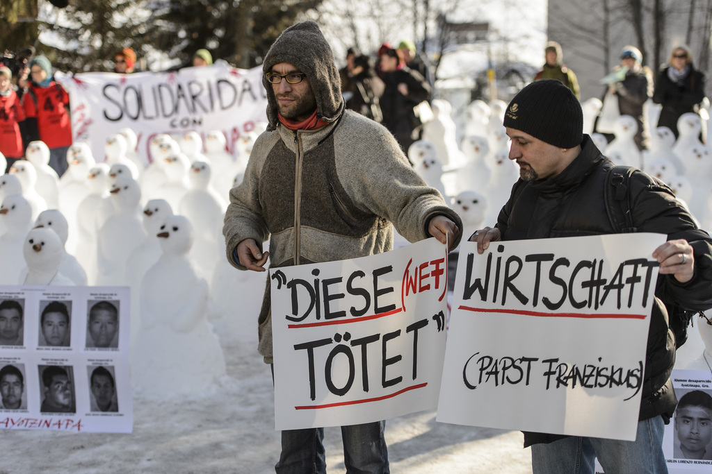 Demonstrators hold banners during a protest against the Davos World Economic Forum, WEF, on the side line of the 45th Annual Meeting of the World Economic Forum, WEF, in Davos, Switzerland, Saturday, January 24, 2015. The overarching theme of the Meeting, which takes place from 21 to 24 January, is "The New Global Context". (KEYSTONE/Jean-Christophe Bott)