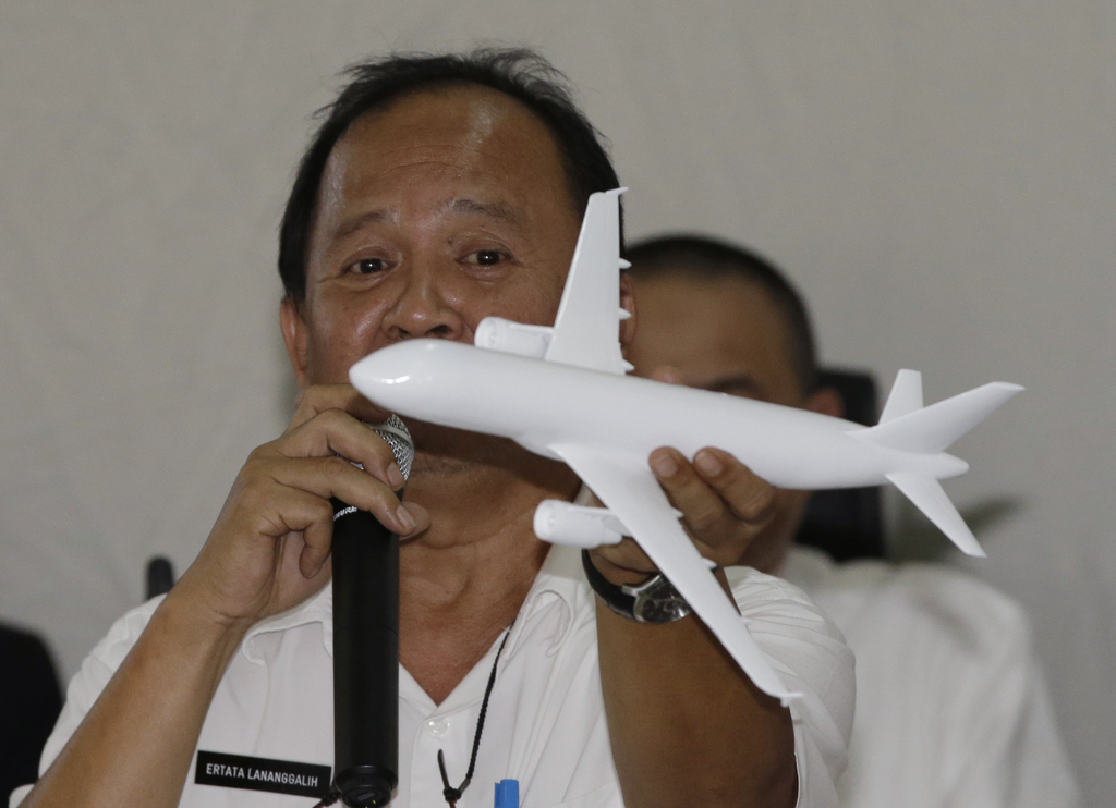 Indonesian National Transportation Safety Committee (KNKT) investigator Ertata Lananggalih holds a model plane as he explains the movement of AirAsia Flight 8501 before it crashed into the Java Sea on Dec. 28 last year during a press conference in Jakarta, Indonesia Thursday, Jan. 29, 2015. Indonesian investigators announced Thursday the co-pilot of the crashed AirAsia jet was in controls when he struggled to recover the aircraft as stall warnings sounded. (AP Photo/Dita Alangkara)