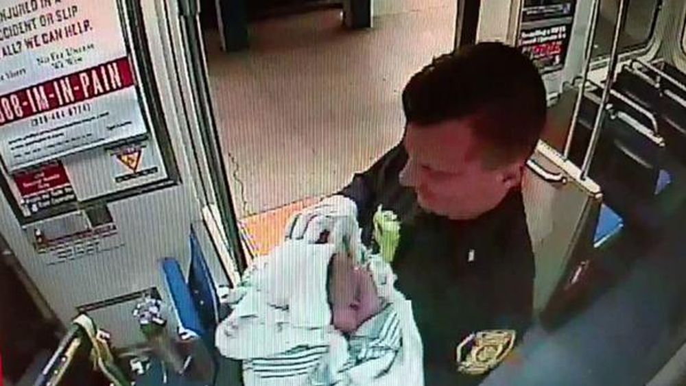 Des photos prises avec un téléphone portable montre l'un des policiers quittant le métro, avec l'enfant emmailloté dans ses bras. 