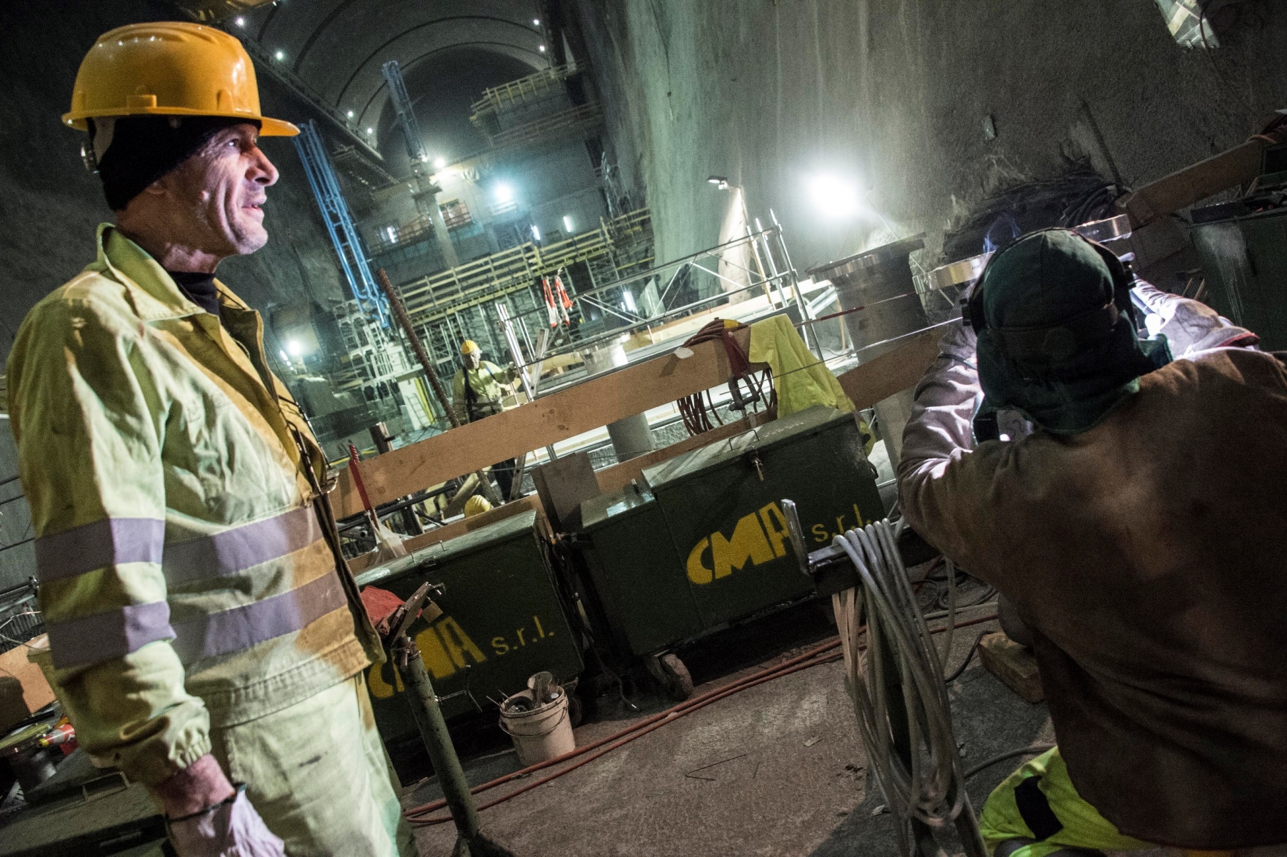 Des dizaines d'ouvriers s'activent 600 mètres sous terre, dans l'imposante cavernes des machines.