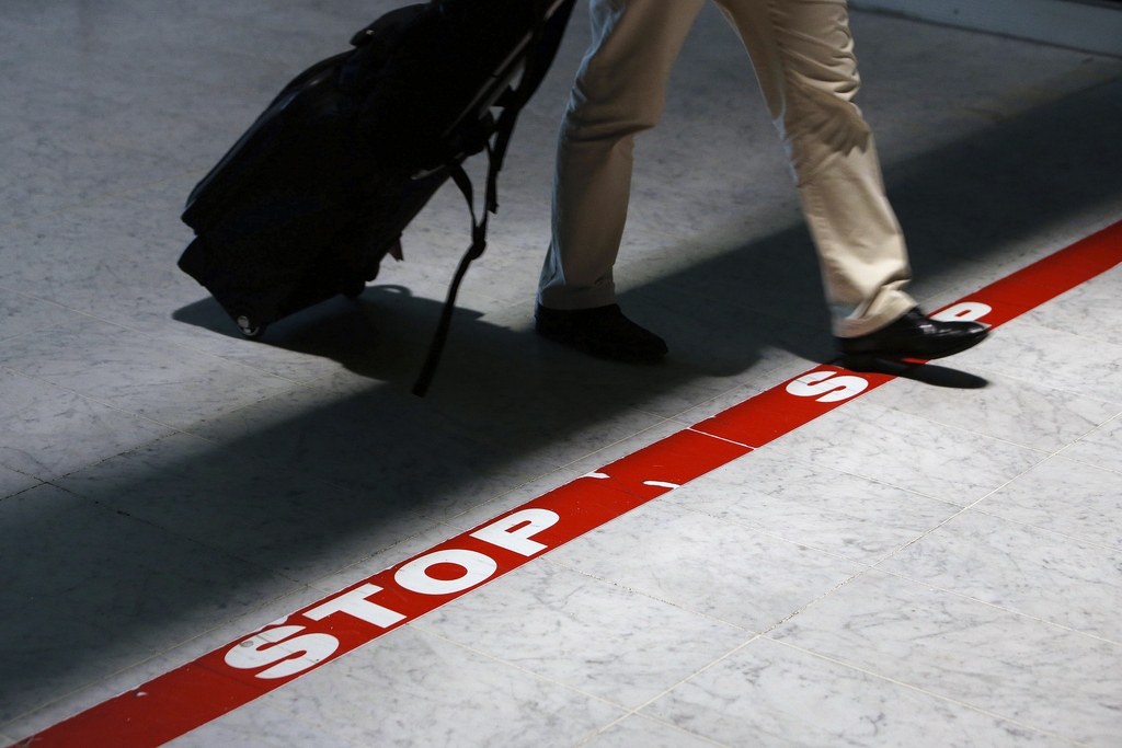A passenger crosses a stop line as he arrives at Roissy Charles de Gaulle airport in Roissy, north of Paris, Saturday, Oct. 18, 2014. France will begin screening airline passengers for Ebola in coming days at Paris' Charles de Gaulle airport. The Paris airport authority says that medical teams will take passengers' temperatures before they leave the air bridge to enter the terminal. (AP Photo/Thibault Camus)
