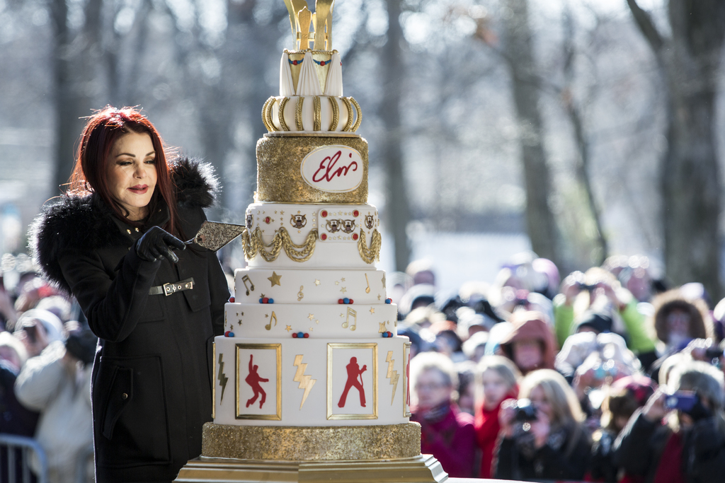 Priscilla Presley cuts the eight-tiered birthday cake during the 80th birthday celebration for her late ex-husband Elvis Presley at Graceland, Thursday, Jan. 8, 2015, in Memphis, Tenn. A large crowd gathered for the celebration even though the temperature was below 20 degrees. (AP Photo/The Commercial Appeal, Brad Vest)