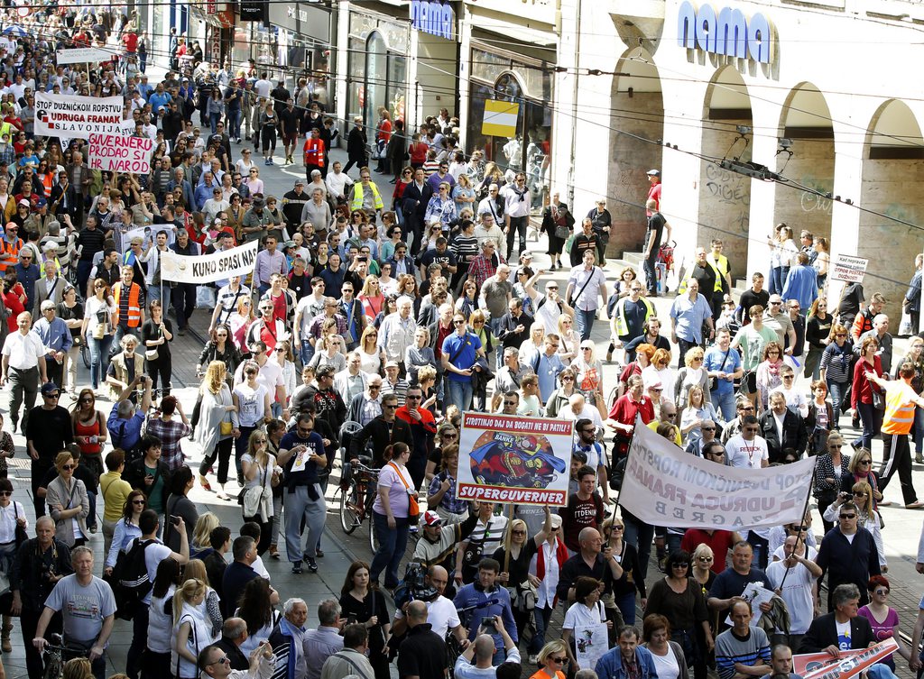 epa04720208 Croatian protesters gather to demand the conversion of Swiss franc-denominated loans into Croatian kuna in front of Croatian National Bank (HNB) in downtown Zagreb, Croatia, 25 April 2015. Reports state thousands of Croatians resorted to Swiss franc-denominated loans due to the low interest rates; however the strong Swiss franc, which has gained value since the Swiss National Bank gave up its minimum exchange rate against the euro in January, caused an increase in the cost of loans. Croatian borrowers want to convert the loans into Croatian kuna, a demand rejected by the HNB fearing it would add downward pressure on their national currency.  EPA/ANTONIO BAT