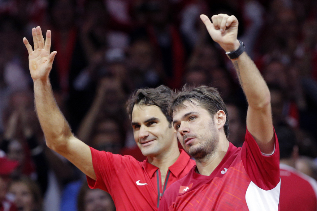 Switzerland's Roger Federer, left, and compatriot  Stanislas Wawrinka, right wave after defeating  French pair Julien Benneteau and Richard Gasquet in their doubles match for the Davis Cup final in Lille, northern France, Saturday, Nov.22, 2014. Switzerland leads France 2-1.(AP Photo/Christophe Ena)
