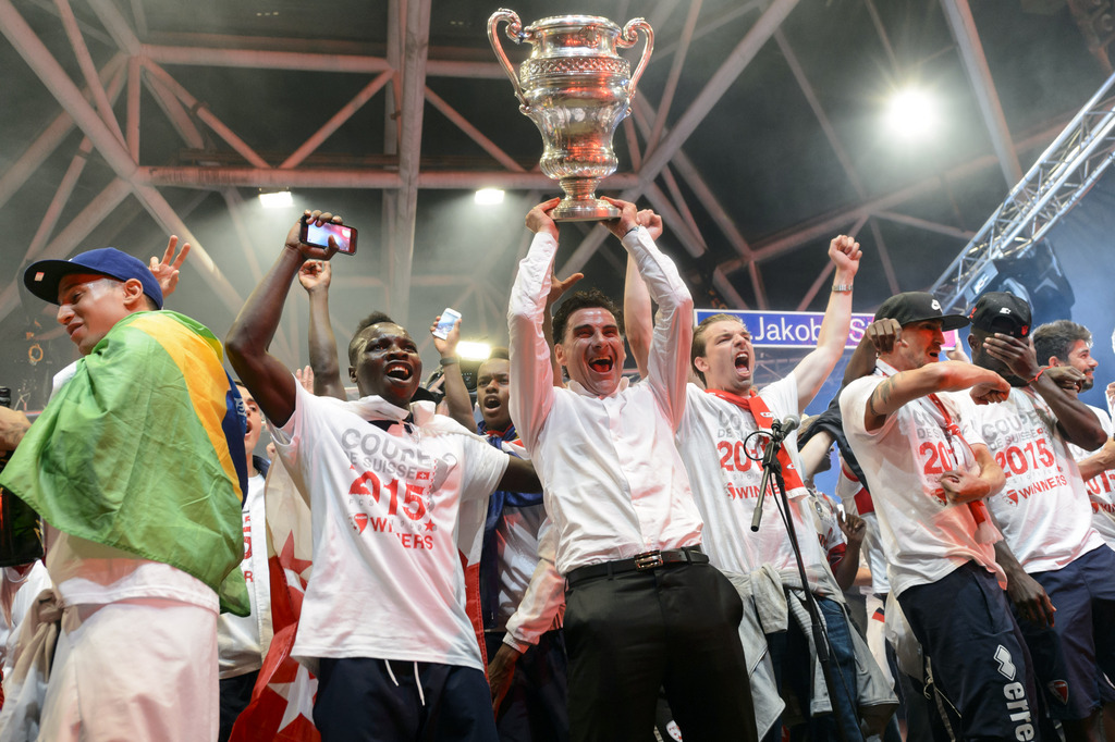 FC Sion players celebrates with FC Sion head coach Didier Tholot, center with the trophy, on stage in front of their fans after they won the Swiss Cup final soccer match against FC Basel, in Sion, Switzerland, late Sunday, June 7, 2015. (KEYSTONE/Jean-Christophe Bott)