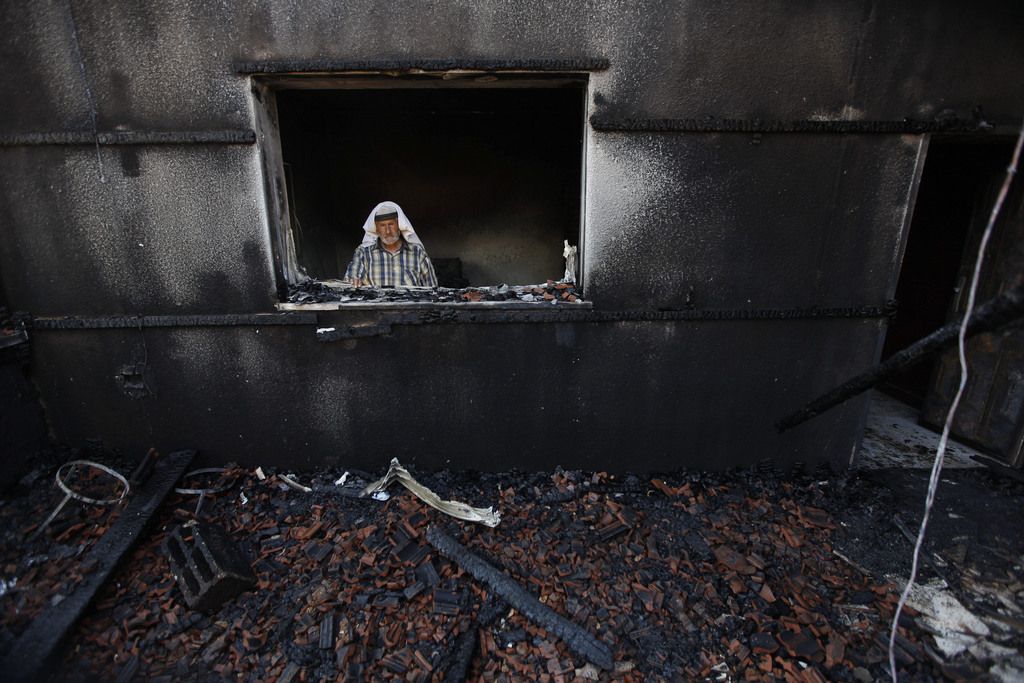 A Palestinian man inspects a house after it was torched in a suspected attack by Jewish settlers killing an 18-month-old  Palestinian child, his four-year-old brother and parents were wounded, according to a Palestinian official from the Nablus area. at Duma village near the West Bank city of Nablus, Friday, July 31, 2015. (AP Photo/Majdi Mohammed)